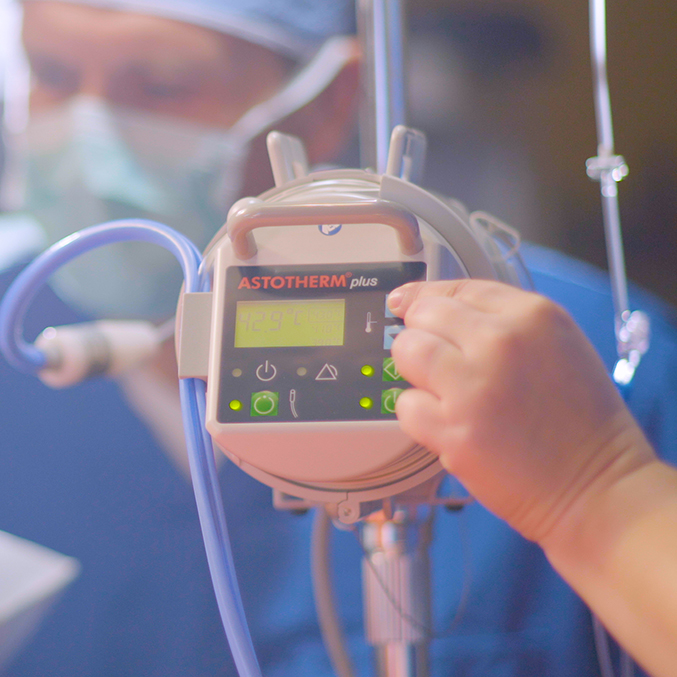 Nurse pressing a button on the Astotherm Plus fluid warming device